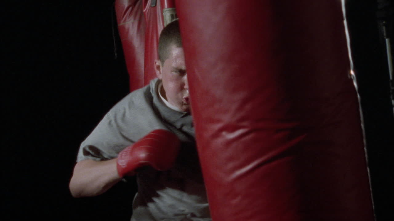 un hombre golpea un saco de boxeo 2