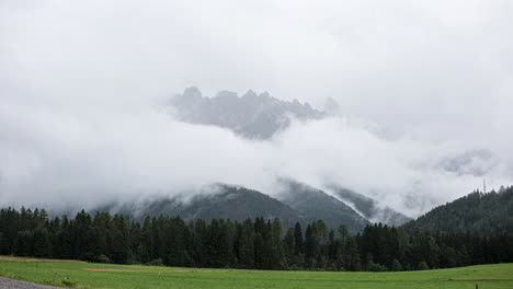developing clouds swirling around rugged dolomites alpine woodland mountain range time lapse