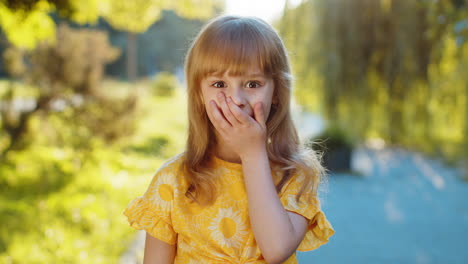 child girl kid looking surprised at camera shocked by game win good victory news wow in city park