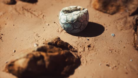 old football ball on the sand beach