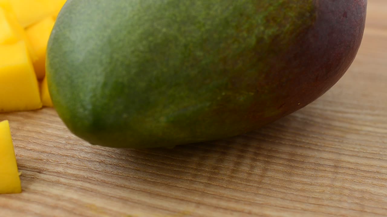 Kawałki mango na drewnianej desce. Ujęcie w ruchu.