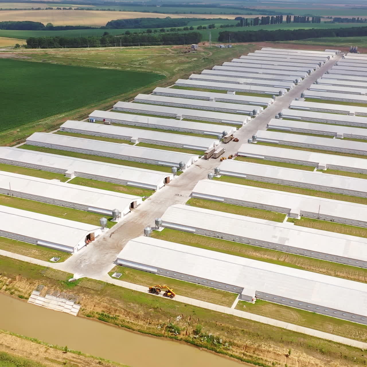 Farm of modern agricultural business approach. Two rows of modern buildings for farming outdoors. Aerial view.