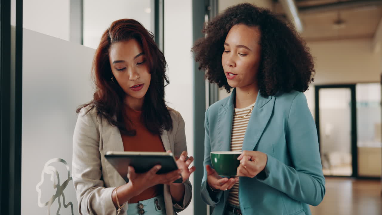 Two Businesswomen Talking and Working Together in an Office