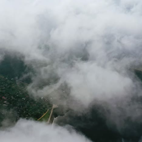 light clouds moving in the sky. city view from the air through white clouds. flying over the river and country. aerial view.