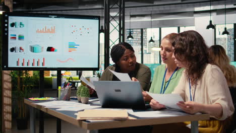 vertical video businesswomen compare analytics and plan strategy in a modern workspace