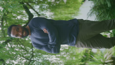 vertical video portrait of relaxed smiling man standing in garden at home after retirement