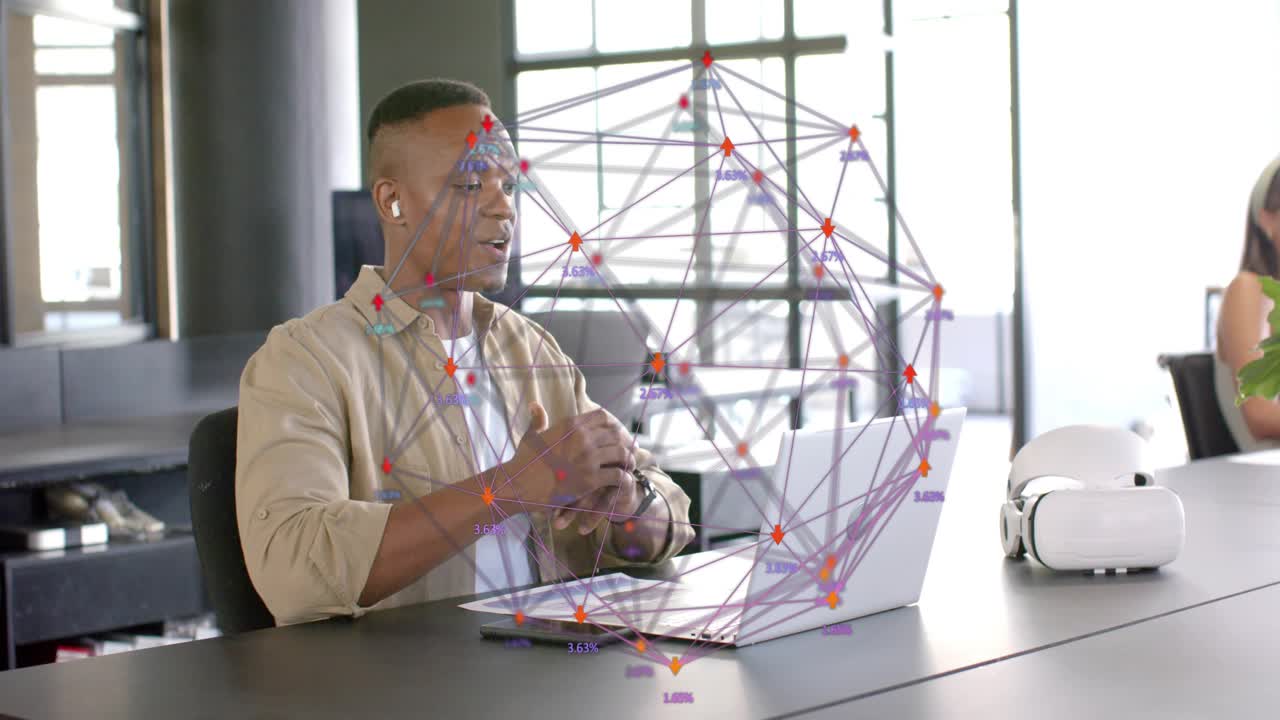Man sitting table speaking into laptop, opening hands, pointing at wireframe globe, explaining tech
