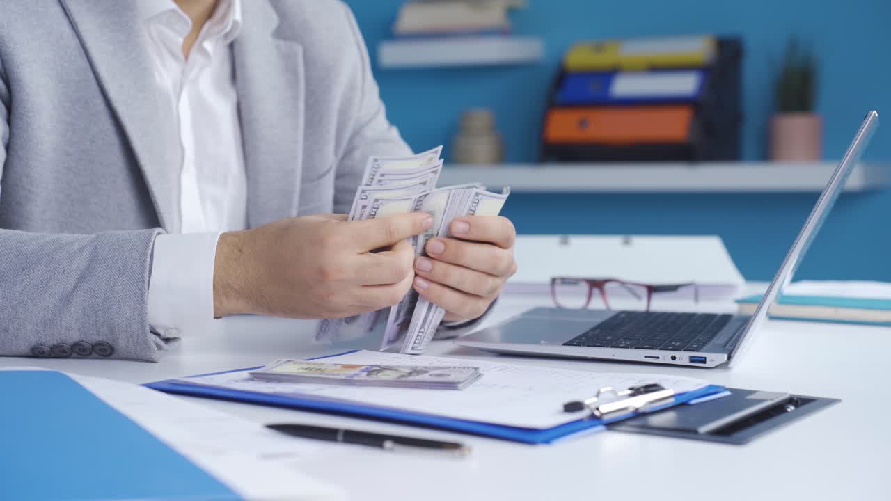 un hombre de negocios rentable contando dinero en su oficina.