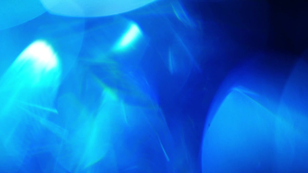 Perdite di luce blu astratte e bagliori dell'obiettivo su sfondo nero