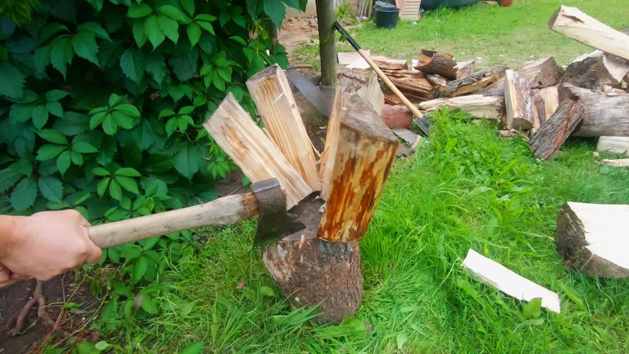 Slow Motion Shot Of A Man With An Ax Splitting Firewood In The Village. Slow Motion Shot