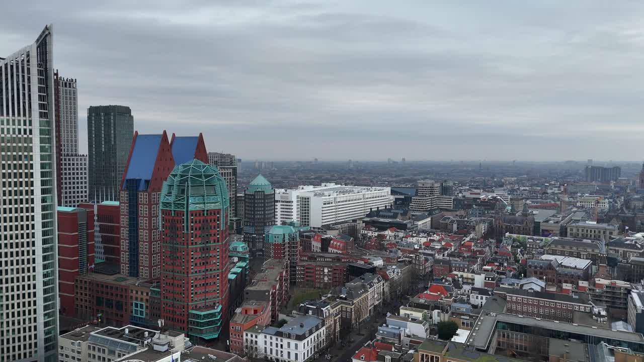The Hague Skyline with high-rise buildings and historic homes along Main street. Aerial approaching wide shot. Cloudy winter day in dutch town.