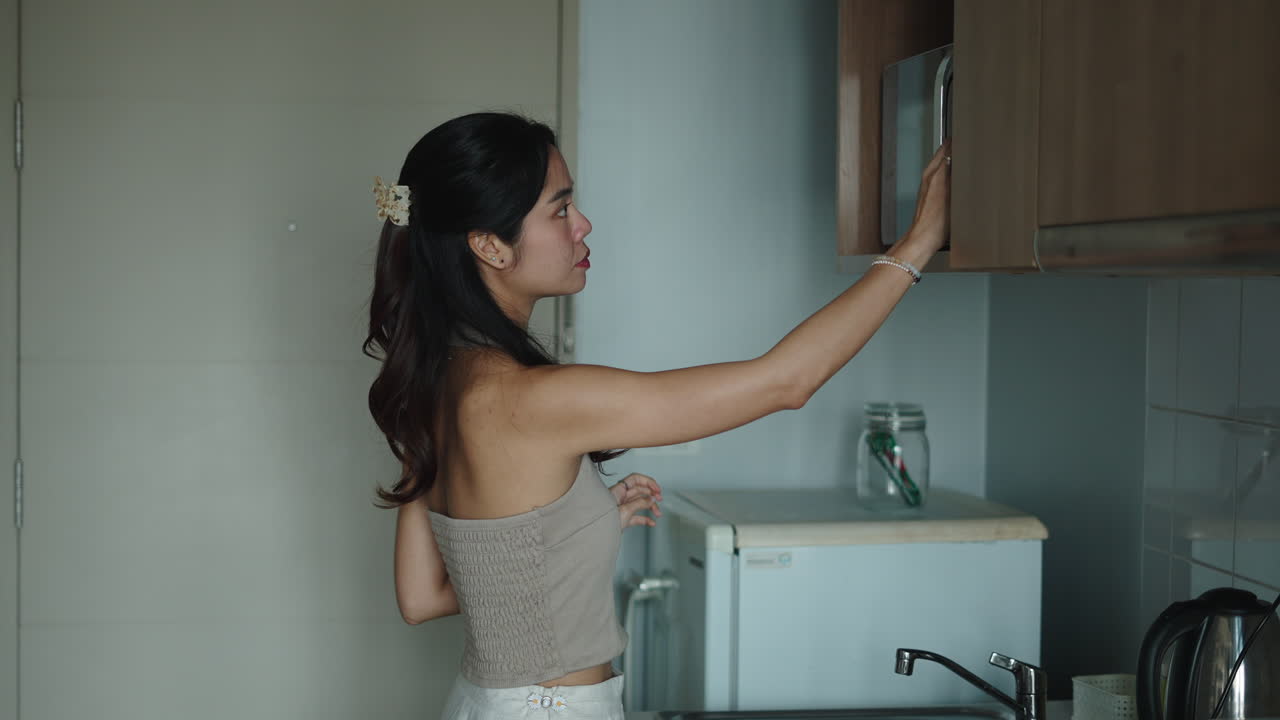 Donna che usa il microonde in cucina