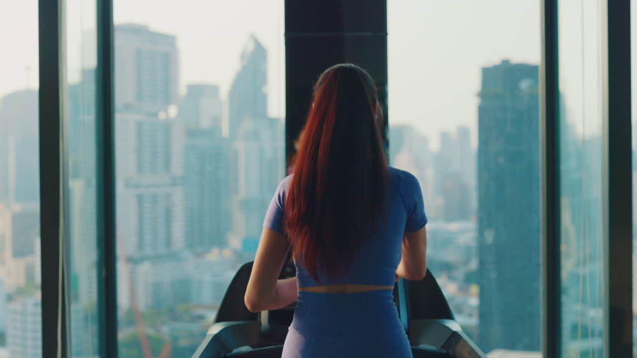 Woman Working Out on Treadmill with City View