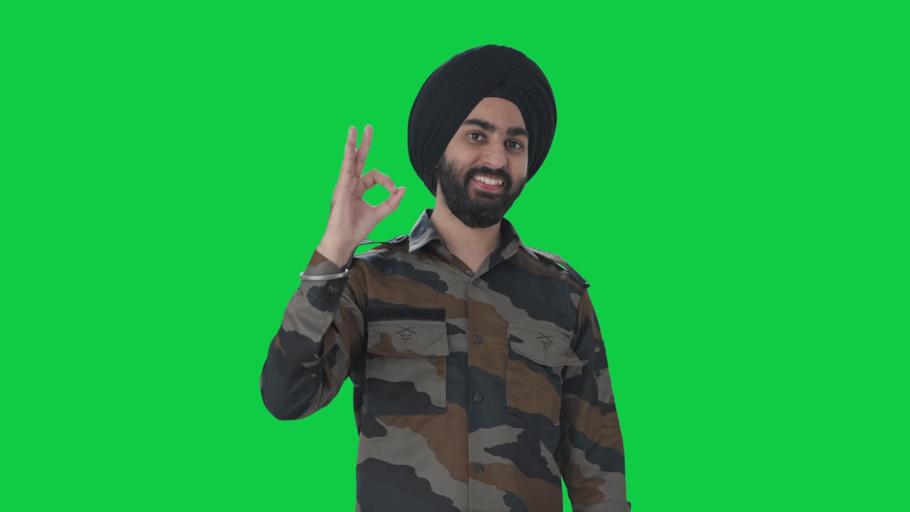 feliz sikh hombre del ejército indio mostrando bien señal pantalla verde