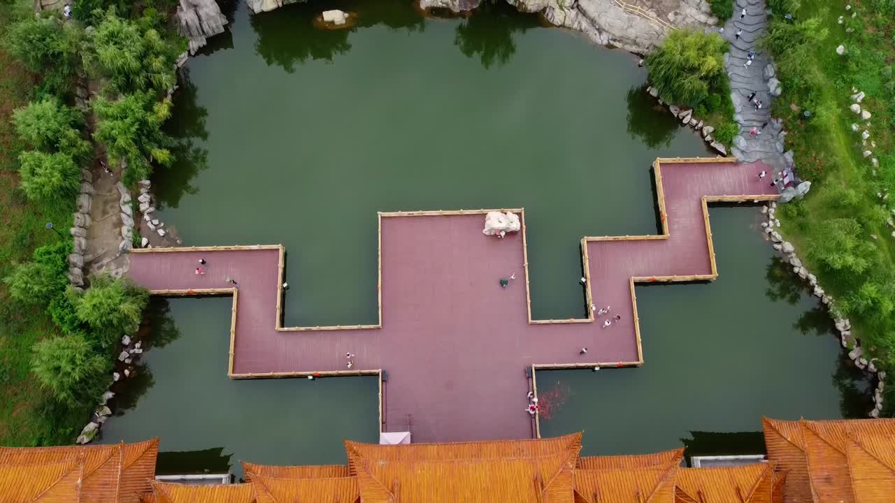 hermoso carrito cinematográfico hacia adelante más inclinación hacia arriba más vista de edificios tradicionales chinos resort con lagos y fondo de montaña