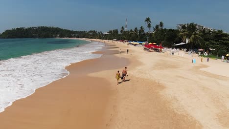 toma de seguimiento de personas caminando con los pies descalzos en una larga playa de arena, disfrutando del verano, sri lanka