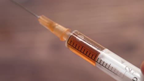 close-up of a syringe filled with brown liquid