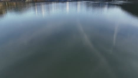 calm lake reflecting a bridge near steinbach with snow-capped mountains in the background, tranquil scene, aerial view