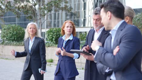 group of business professionals discussing outdoors