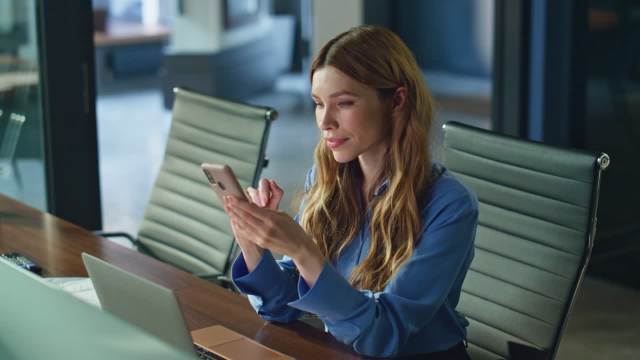 Businesswoman reading cellphone message at work desk closeup. Serious executive