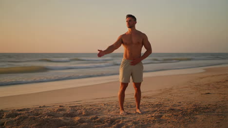 man standing on a beach at sunset