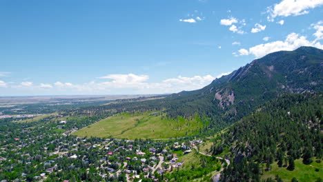 tiro aéreo de hd drone volando sobre las afueras de la ciudad de boulder colorado usa durante el verano con montañas alpinas en el fondo