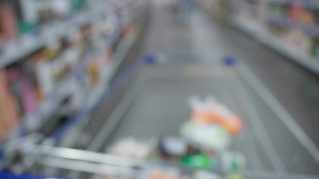 식료품 하이퍼마켓에서 손에 들고 있는 쇼핑 바구니. 선택적인 초점. 흐릿한, 초점을 벗어내는