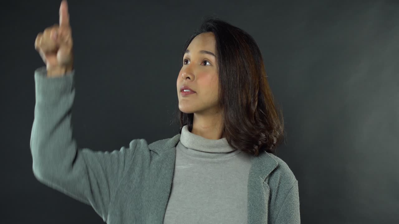 가상 어두운 배경에서 아시아 젊은 패션 모델 제스처 터치 스크린