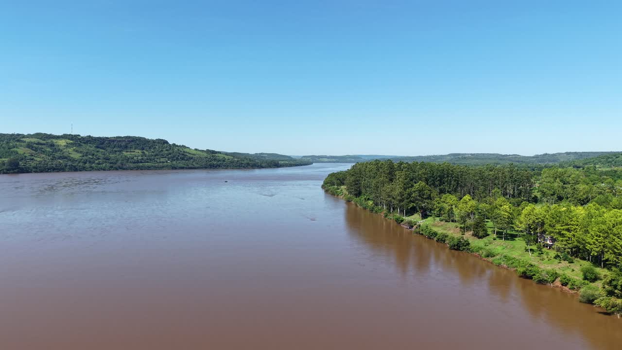 Drone view over Uruguay River near Panambí, Misiones, Argentina, showing pine and eucalyptus plantations, native forest, with biodiverse subtropical landscape shaped by forestry and conservation