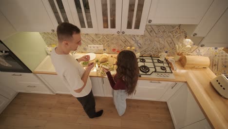 una pareja enamorada haciendo un sándwich en la cocina de la sala de estar