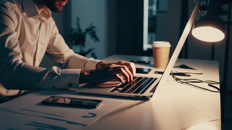 man working late night on laptop in office