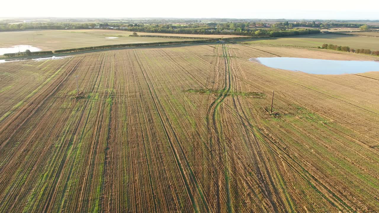 Aerial footage flying over a scarred, tracked farmer's field in North Yorkshire, UK on a beautiful, sunny autumn morning