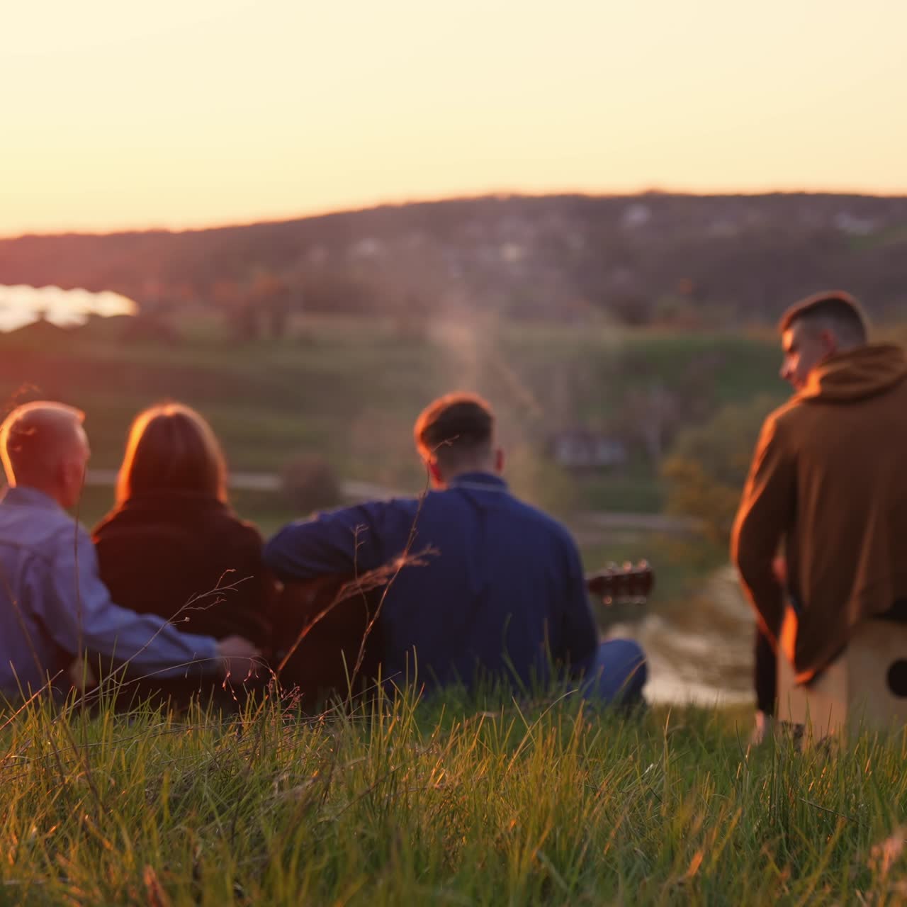 Lifestyle outdoor people friendship. Friends sitting on nature sunset