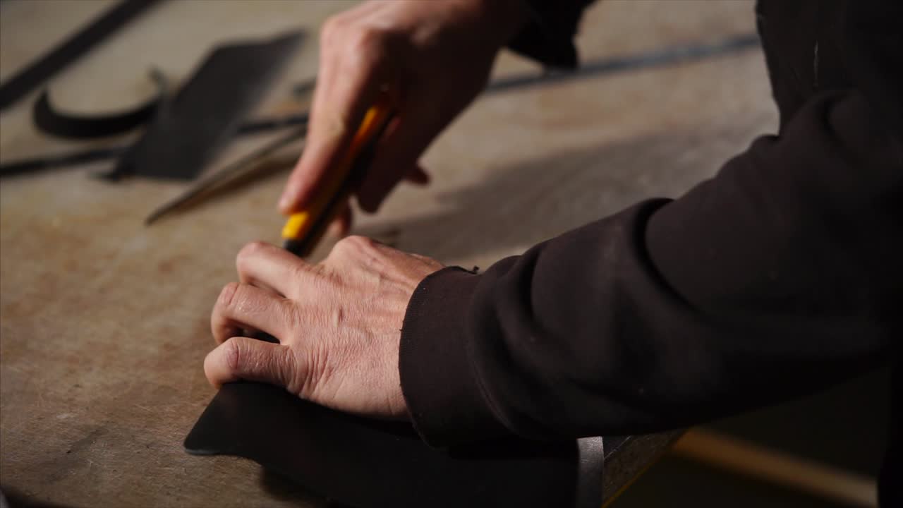 Person Cutting Leather with a Knife