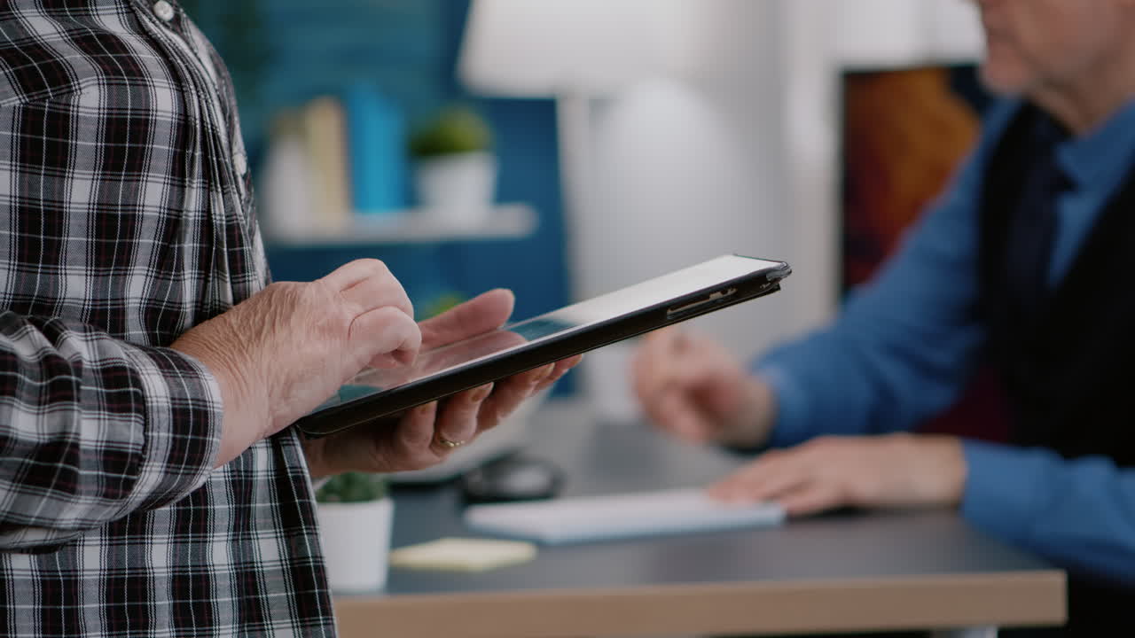 un primer plano de una empleada anciana enviando mensajes de texto, leyendo mensajes de su tableta.