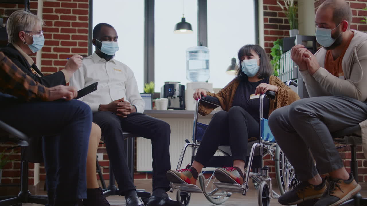 Woman with addiction sitting in wheelchair at aa meeting to do grpup therapy with psychiatrist