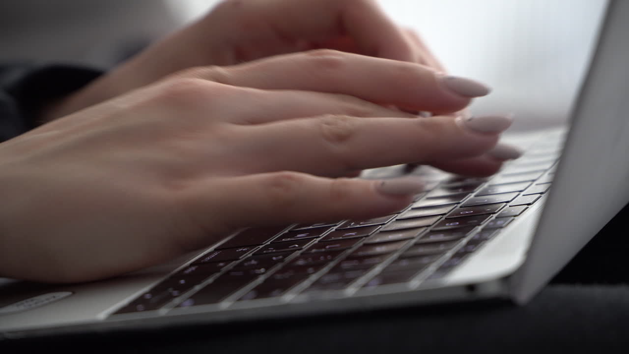 manos femeninas presionan teclas en el teclado de un macbook con un diseño ruso