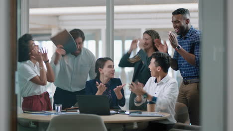 Grupo-De-Empresarios-Celebrando-El-éxito-Viendo-La-Pantalla-Del-Portátil-Colegas-Felices-Aplaudiendo-Disfrutando-Del-Exitoso-Logro-De-La-Victoria-Corporativa-En-La-Oficina-Moderna-4k