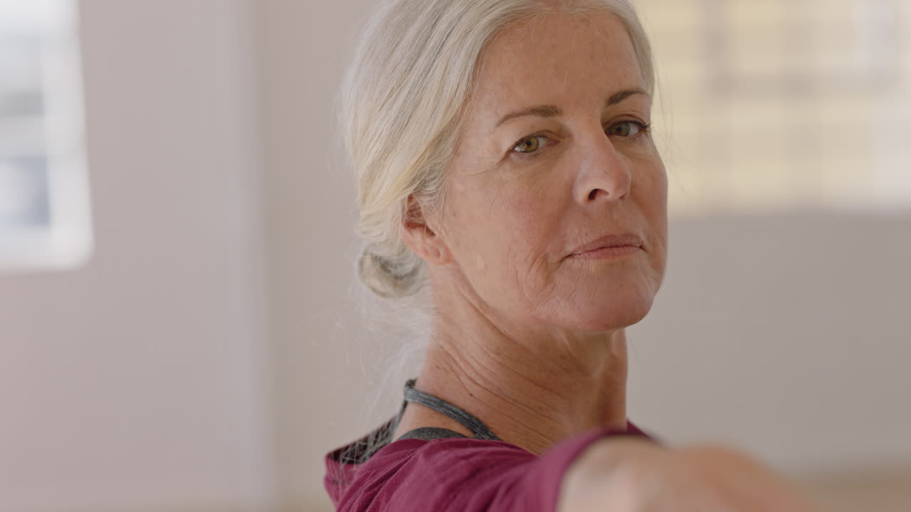 clase de yoga de mujeres maduras sanas instructor de ejercicio enseñando pose de guerrero postura de entrenamiento disfrutando del entrenamiento físico matutino en el estudio