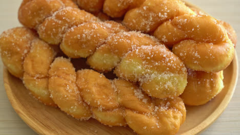 sugar-doughnut-in-spiral-shape-on-wooden-plate