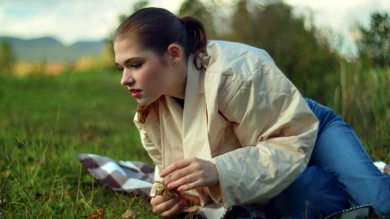 Woman Picking Leaves in Autumn Park