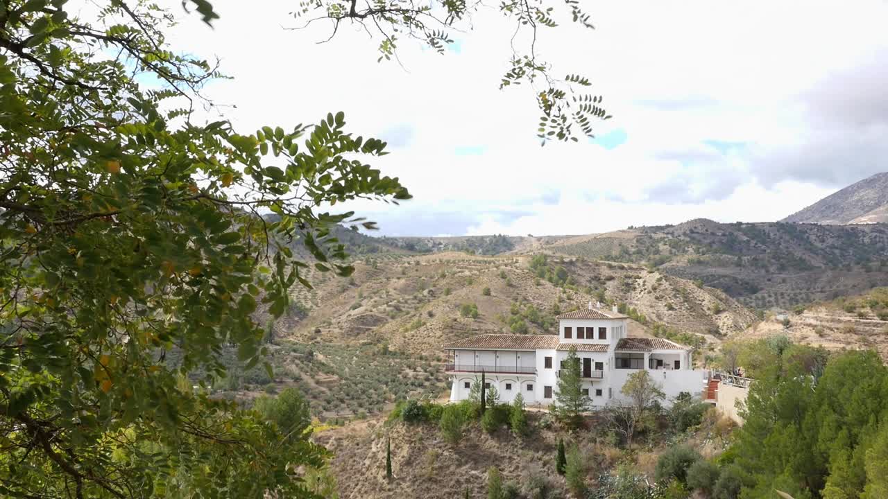 Vista general del Centro de Visitantes Sierra de Castril. Luz natural sobre las montañas mediterráneas y olivares. Turismo rural, arquitectura española y conservación de la naturaleza.