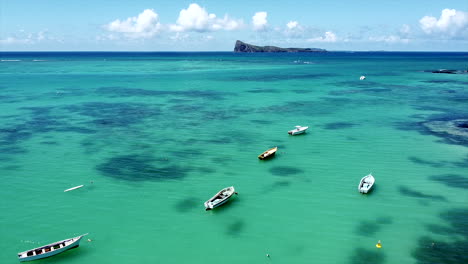 Dolly-slow-aerial-forward-shot-of-boats-on-crystal-clear-indian-ocean-in-summer