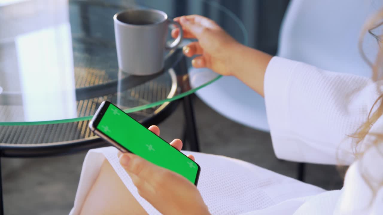 여성은 크로마 키 스크린으로 전화를 사용합니다.