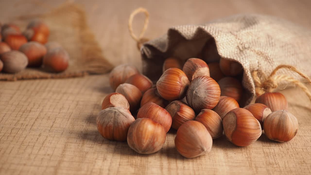 Hazelnuts Spilled from Burlap Sack on Wooden Surface