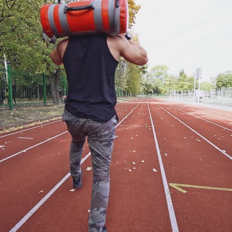 . young man exercising outdoors. muscular built young athlete working out on stadium