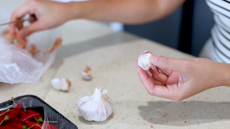 close-up of hands peeling garlic on a kitchen counter with natural lighting and a relaxed atmosphere