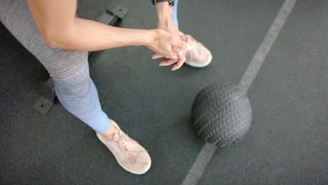 fit young caucasian woman prepares for a workout at the gym with a medicine ball