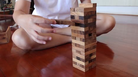 person playing jenga, carefully removing blocks