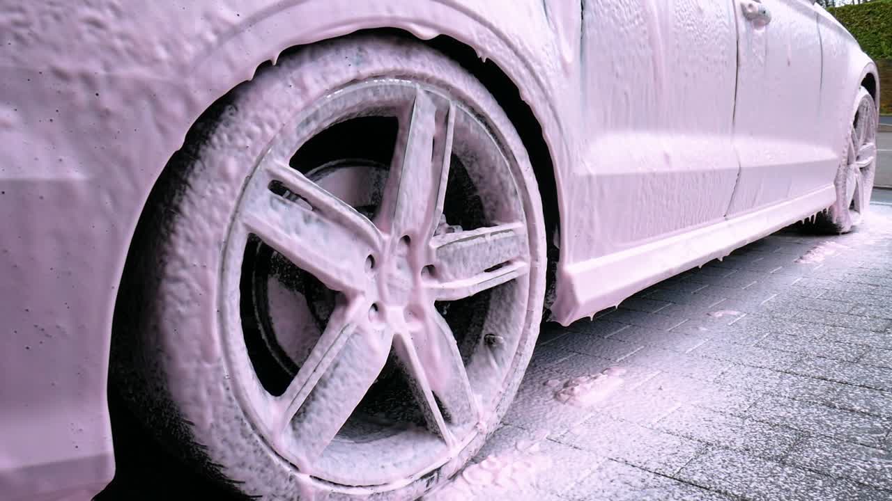 Alloy Wheel Covered In Pink Snow Foam Dripping